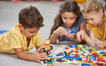 Children building with coloured blocks in a classroom