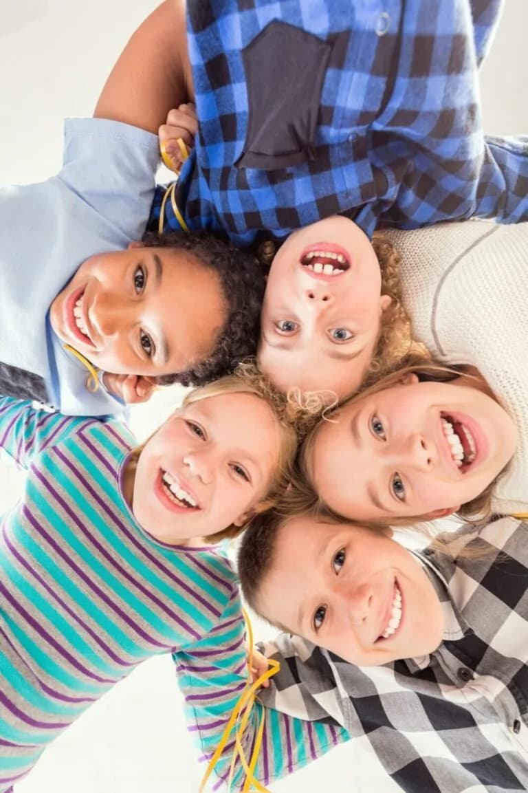 A circle of children looking down at the camera together